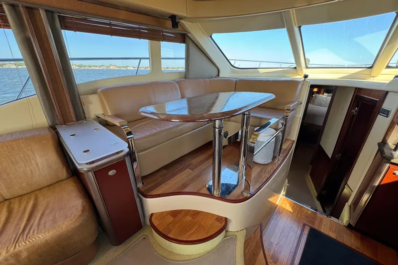 Slide: The Image of Luxurious interior of 2005 Sea Ray 500 Sedan Bridge yacht with leather seating and wooden table. - 26