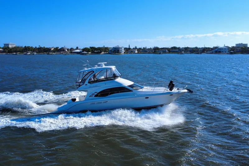 Slide: The Image of 2005 Sea Ray 500 Sedan Bridge yacht cruising on open water under clear blue skies. - 3