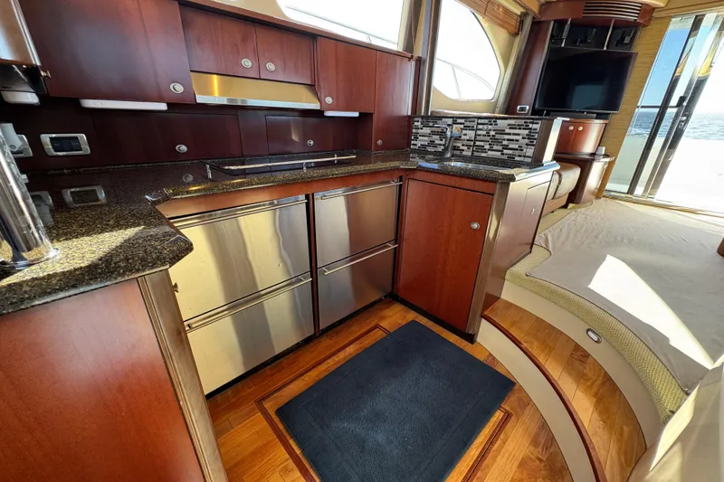 Slide: The Image of Luxurious 2005 Sea Ray 500 Sedan Bridge yacht interior with modern kitchen and elegant wood finishes. - 32