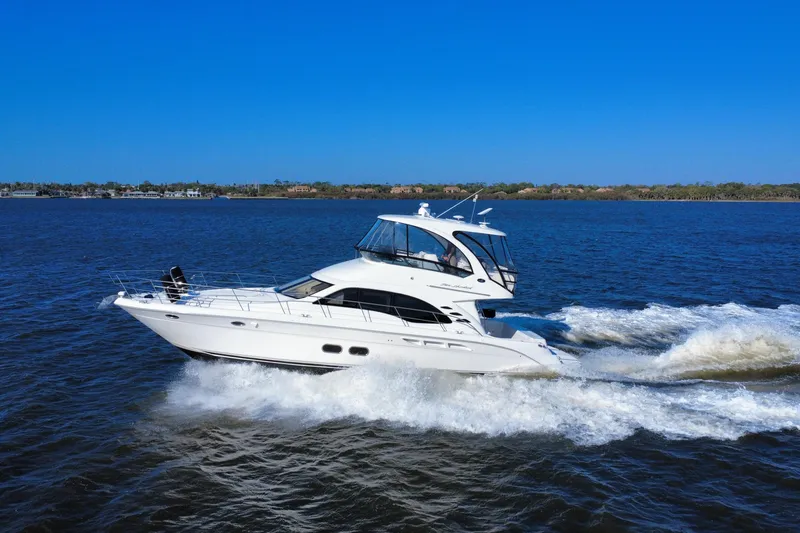 Slide: The Image of 2005 Sea Ray 500 Sedan Bridge yacht cruising on open water under clear blue skies. - 4