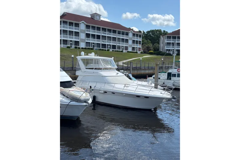 Slide: The Image of 1999 Sea Ray 480 Sedan Bridge yacht docked near waterfront buildings. - 12