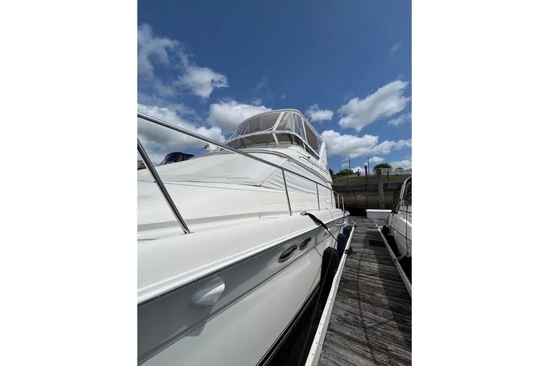 Slide: The Image of 1999 Sea Ray 480 Sedan Bridge yacht docked under a clear blue sky. - 11