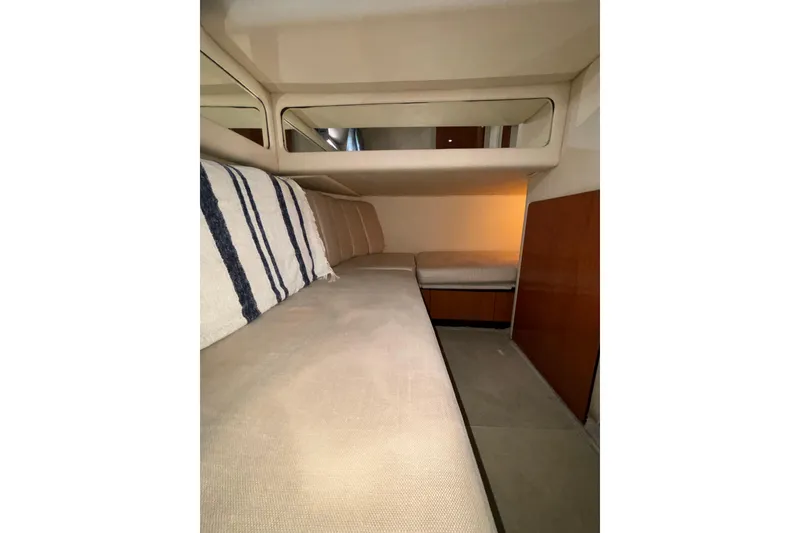 Slide: The Image of Interior cabin of 1999 Sea Ray 480 Sedan Bridge with beige seating and striped pillow. - 64