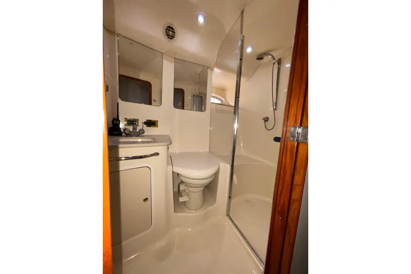 Slide: The Image of Bathroom interior of 1999 Sea Ray 480 Sedan Bridge yacht, featuring shower and toilet. - 58