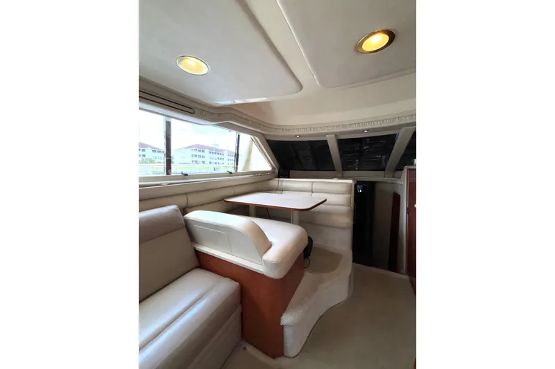 Slide: The Image of Interior of 1999 Sea Ray 480 Sedan Bridge yacht with plush seating and dining area. - 42