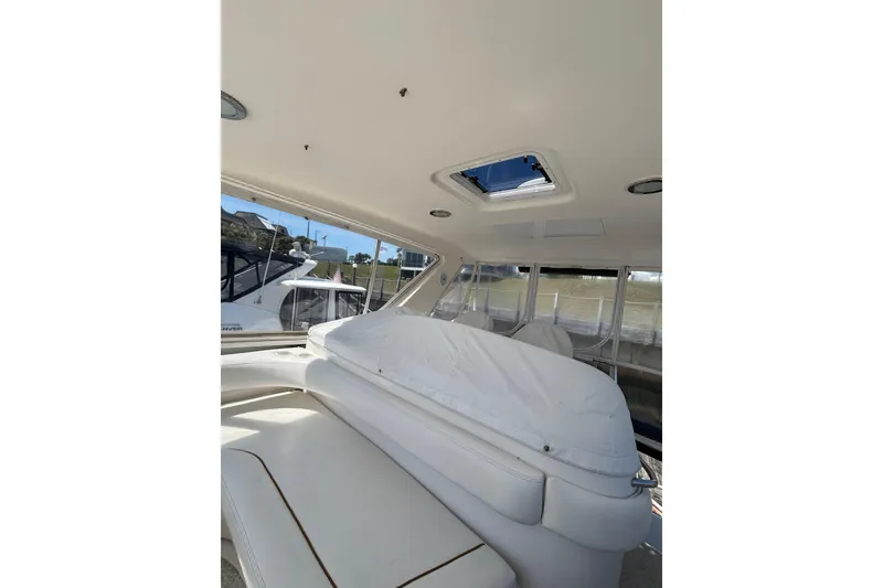 Slide: The Image of 1999 Sea Ray 480 Sedan Bridge interior with white seating and overhead hatch. - 24