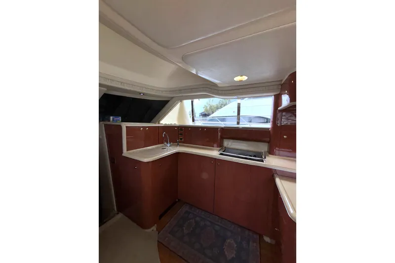 Slide: The Image of Interior of 1999 Sea Ray 480 Sedan Bridge yacht kitchen with wood cabinetry and countertop. - 45