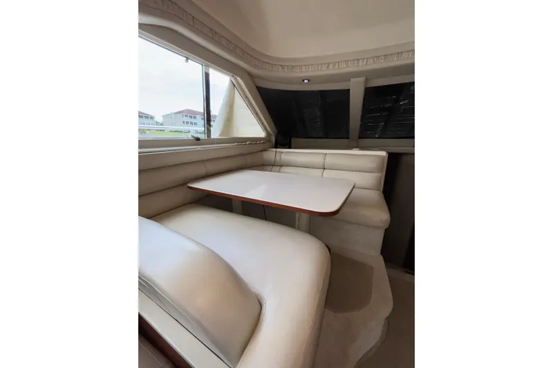 Slide: The Image of Interior of 1999 Sea Ray 480 Sedan Bridge with cream leather seating and table. - 43