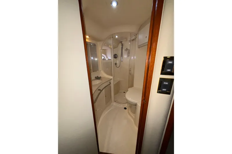 Slide: The Image of Bathroom interior of 1999 Sea Ray 480 Sedan Bridge yacht, featuring shower and toilet. - 77
