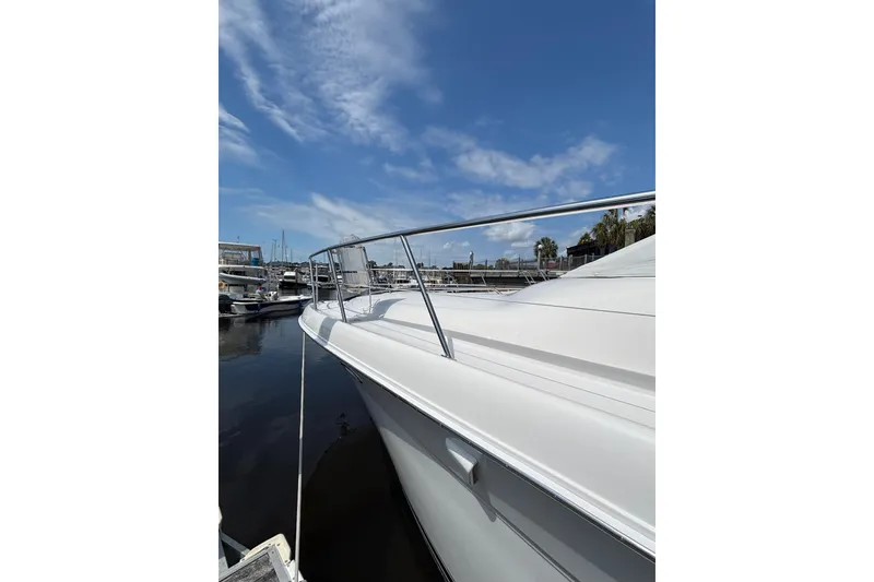 Slide: The Image of 1999 Sea Ray 480 Sedan Bridge yacht docked under a clear blue sky. - 13