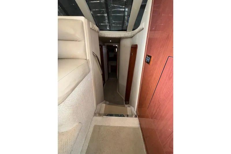Slide: The Image of Interior hallway of a 1999 Sea Ray 480 Sedan Bridge yacht, featuring carpeted steps and wood paneling. - 51