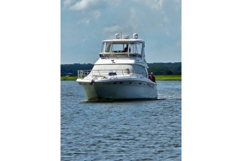 Slide: The Image of 1999 Sea Ray 480 Sedan Bridge yacht cruising on a calm lake. - 4