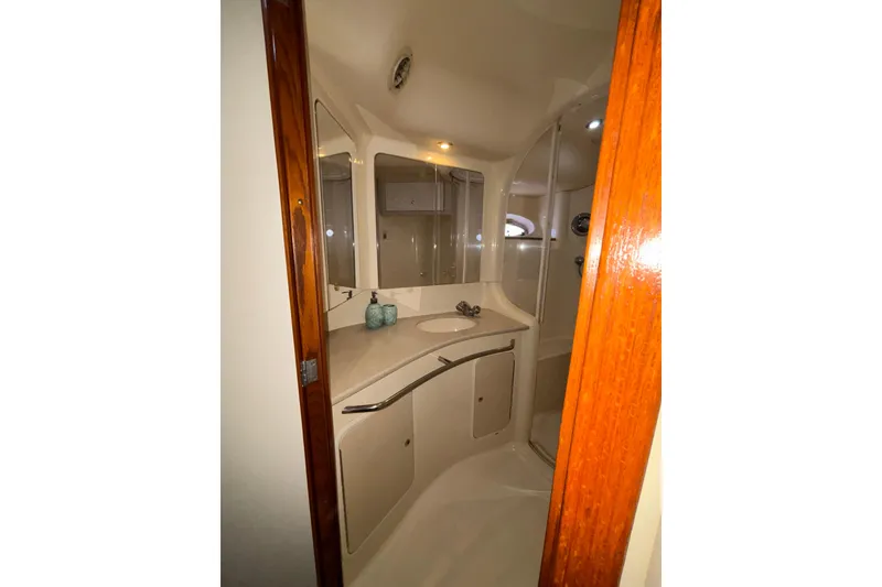 Slide: The Image of 1999 Sea Ray 480 Sedan Bridge bathroom with sink, mirror, and shower. - 76