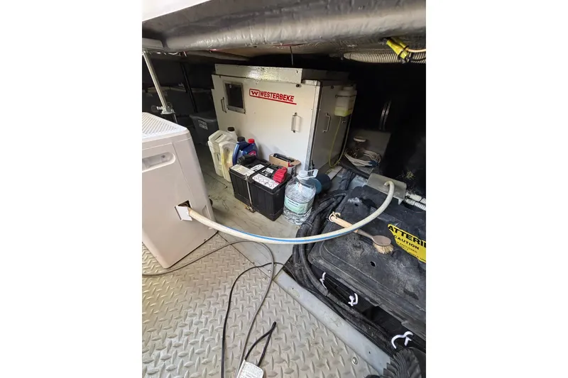 Slide: The Image of Engine room of 1999 Sea Ray 480 Sedan Bridge with Westerbeke generator and maintenance supplies. - 104