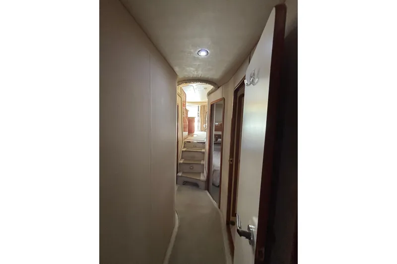 Slide: The Image of Interior hallway of 1999 Sea Ray 480 Sedan Bridge yacht, featuring stairs and doors. - 66