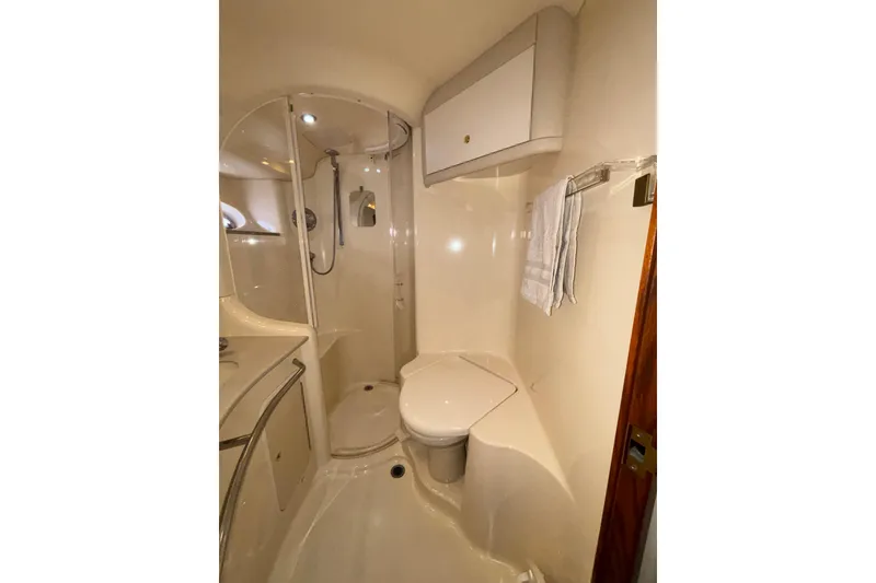 Slide: The Image of Bathroom interior of 1999 Sea Ray 480 Sedan Bridge yacht, featuring shower and toilet. - 78