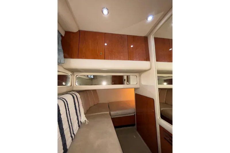 Slide: The Image of 1999 Sea Ray 480 Sedan Bridge interior cabin with wood cabinets and cozy seating. - 62