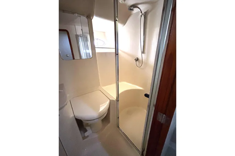 Slide: The Image of Bathroom interior of 1999 Sea Ray 480 Sedan Bridge yacht, featuring shower and toilet. - 59