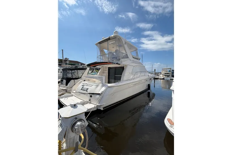 Slide: The Image of 1999 Sea Ray 480 Sedan Bridge yacht docked at marina under clear blue sky. - 9