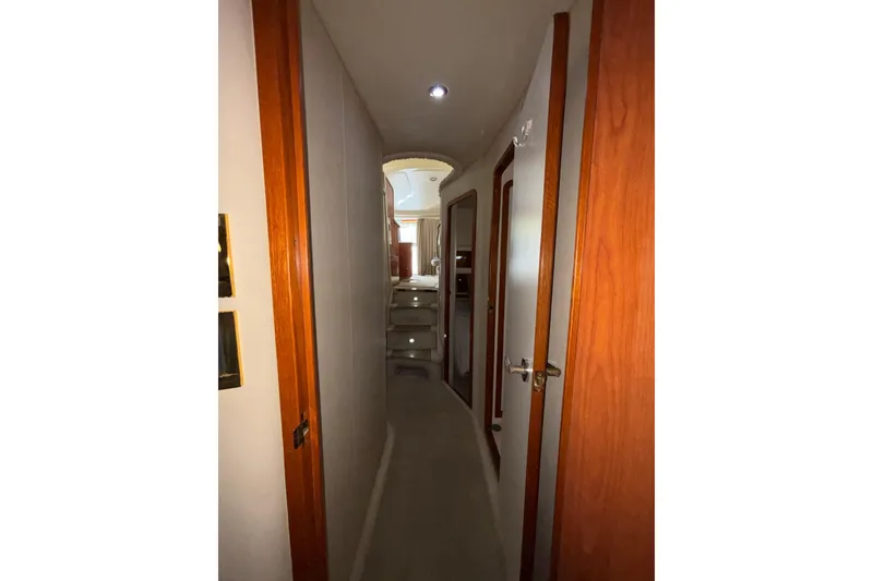 Slide: The Image of Interior hallway of 1999 Sea Ray 480 Sedan Bridge yacht, featuring wooden doors and soft lighting. - 80