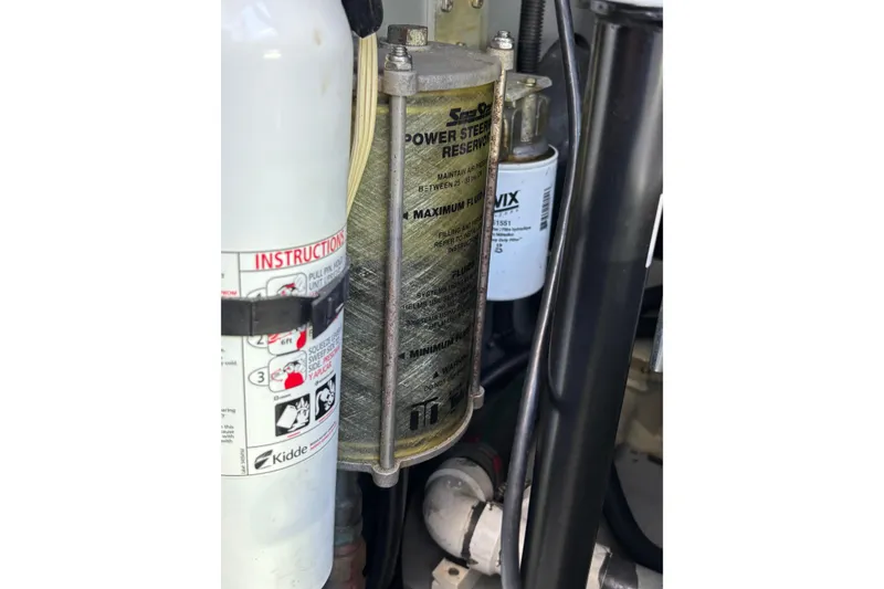 Slide: The Image of Power steering reservoir and fire extinguisher in 1999 Sea Ray 480 Sedan Bridge engine room. - 94