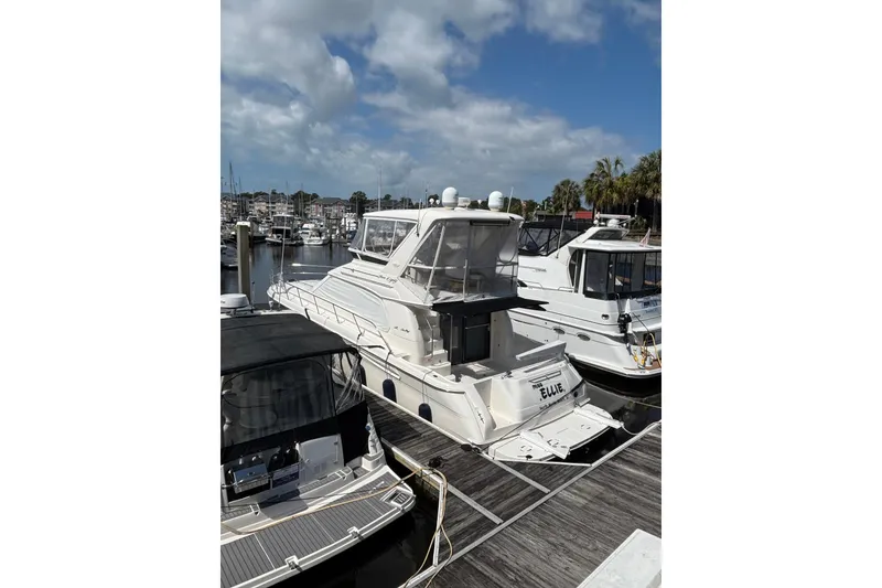 Slide: The Image of 1999 Sea Ray 480 Sedan Bridge yacht docked at marina under blue sky. - 5