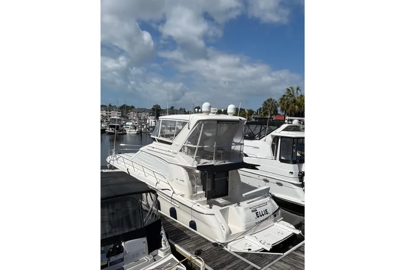 Slide: The Image of 1999 Sea Ray 480 Sedan Bridge yacht docked at marina under cloudy sky. - 8