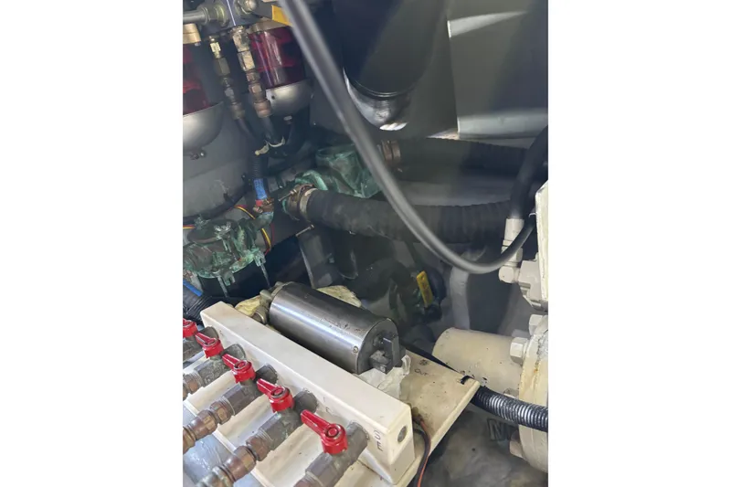 Slide: The Image of Engine compartment of a 1999 Sea Ray 480 Sedan Bridge, showcasing mechanical components and hoses. - 91