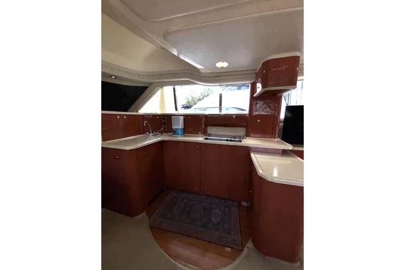 Slide: The Image of Interior of 1999 Sea Ray 480 Sedan Bridge yacht, featuring a modern kitchen area. - 44