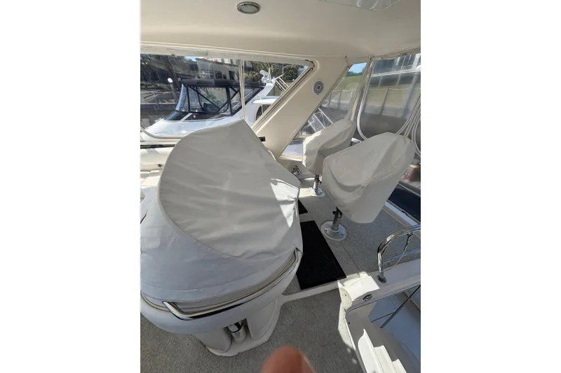 Slide: The Image of 1999 Sea Ray 480 Sedan Bridge interior with covered seating and helm station. - 34