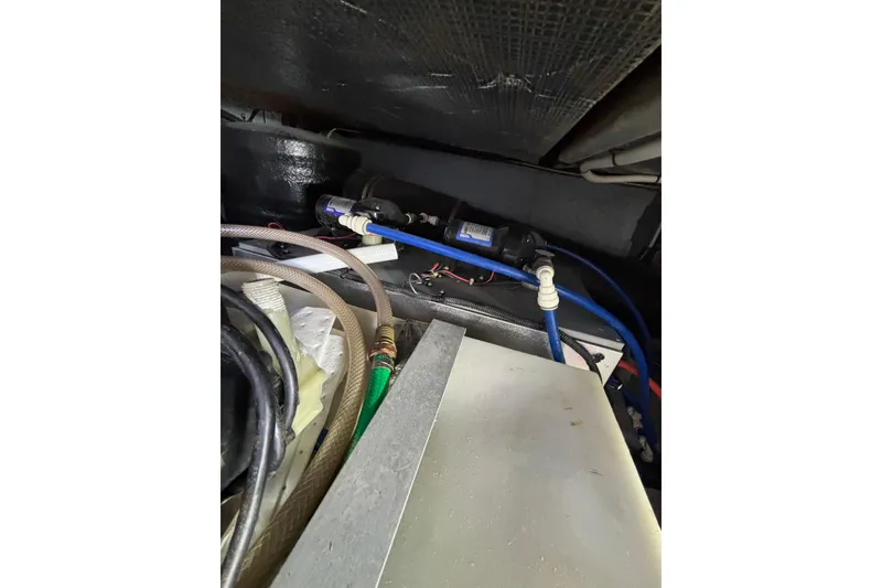 Slide: The Image of Engine compartment of a 1999 Sea Ray 480 Sedan Bridge with visible hoses and wiring. - 98