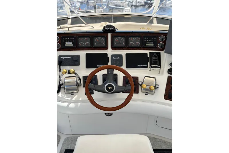 Slide: The Image of 1999 Sea Ray 480 Sedan Bridge helm with Raymarine electronics and wooden steering wheel. - 28