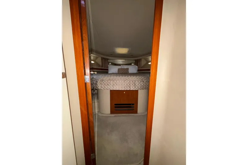Slide: The Image of Interior cabin view of a 1999 Sea Ray 480 Sedan Bridge yacht, featuring a cozy bed. - 68