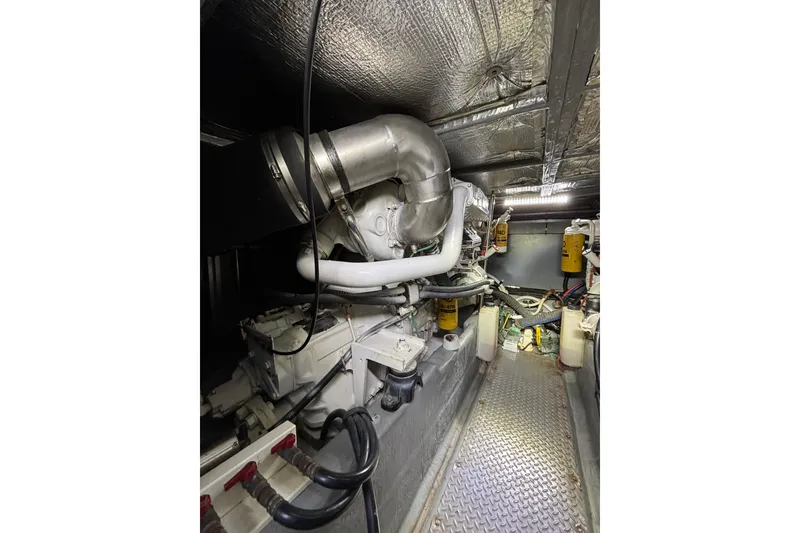 Slide: The Image of Engine room of 1999 Sea Ray 480 Sedan Bridge yacht, showcasing mechanical components and piping. - 82
