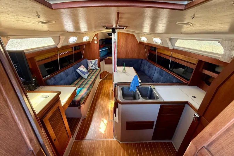 Slide: The Image of Interior of a 1988 Catalina 34 sailboat with cozy seating and wooden finishes. - 15