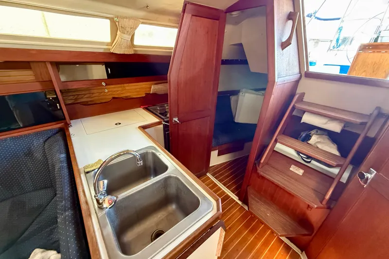 Slide: The Image of Interior of a 1988 Catalina 34 sailboat featuring a compact kitchen area. - 16