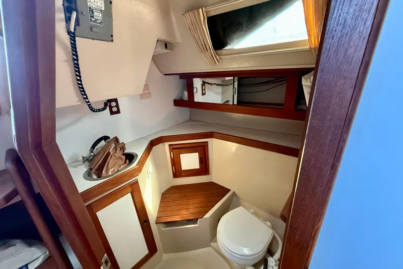 Slide: The Image of 1988 Catalina 34 yacht bathroom with wooden accents, sink, and toilet. - 18