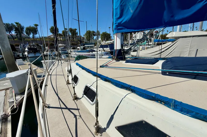 Slide: The Image of 1988 Catalina 34 sailboat docked at marina with blue sail cover. - 4