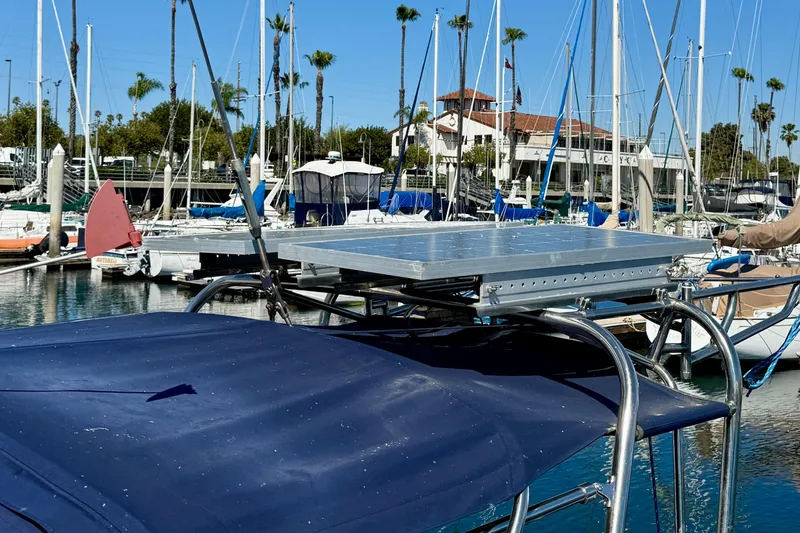 Slide: The Image of Catalina 34 sailboat with solar panel, docked in a marina, surrounded by palm trees. - 7