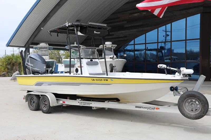 The Image of 2002 Ranger 2300 Bay Ranger boat on trailer with Yamaha engine, parked outdoors. - 1