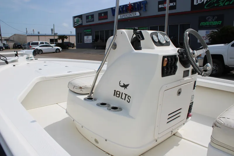 Slide: The Image of 2014 Mako 18 LTS boat console with steering wheel and controls, parked outdoors. - 10