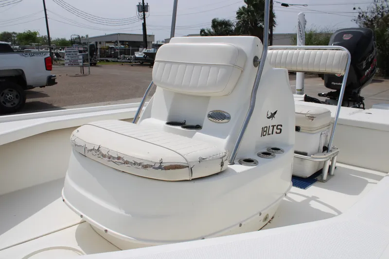 Slide: The Image of 2014 Mako 18 LTS boat interior with worn white seating and cup holders. - 12
