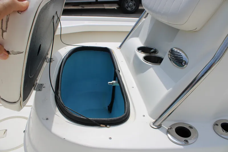 Slide: The Image of Open storage compartment on a 2014 Mako 18 LTS boat with cup holders. - 13