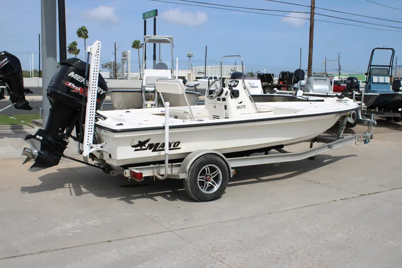 Slide: The Image of 2014 Mako 18 LTS boat on trailer with Mercury engine, parked outdoors. - 6