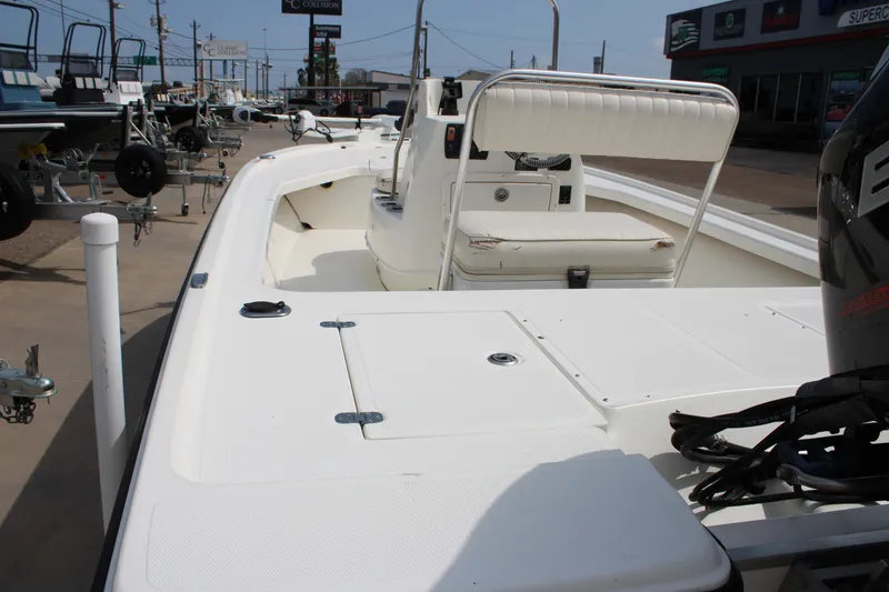 Slide: The Image of 2014 Mako 18 LTS boat with white deck and seating, displayed outdoors. - 9