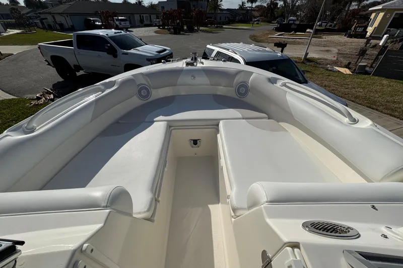 Slide: The Image of Bow seating area of a 2012 Edgewater 245CX Crossover boat, parked in a residential area. - 1