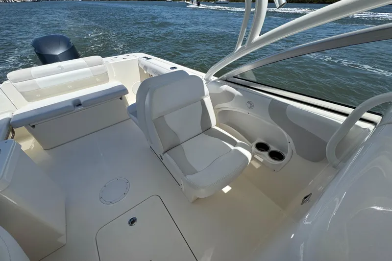 Slide: The Image of 2012 Edgewater 245CX Crossover boat interior with seating and cup holders on the water. - 16