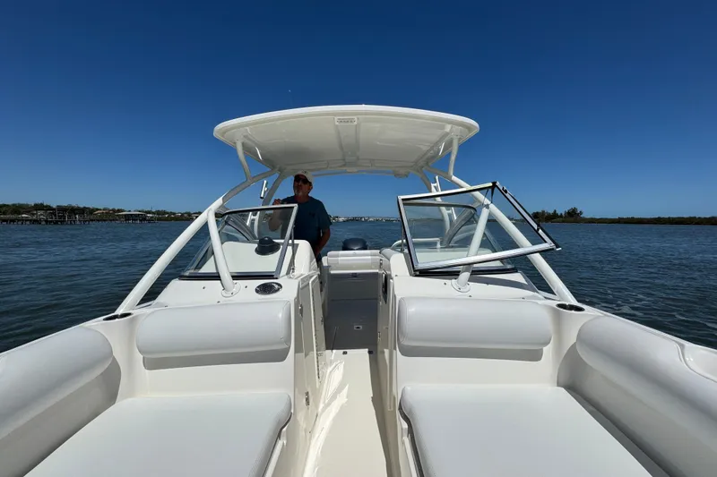 Slide: The Image of Edgewater 245CX Crossover boat on water, 2012 model, clear sky, person onboard. - 17