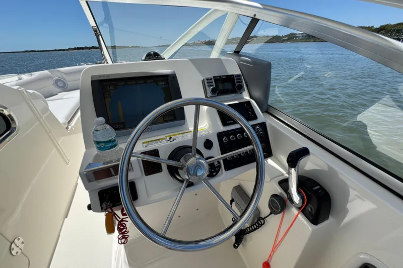 Slide: The Image of Helm of 2012 Edgewater 245CX Crossover boat with steering wheel and navigation equipment. - 19