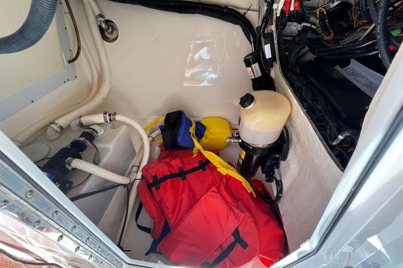Slide: The Image of Storage compartment of 2012 Edgewater 245CX Crossover boat with life jackets and equipment. - 24
